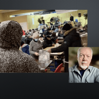 A man in a crowd of people with a person wearing a hood.