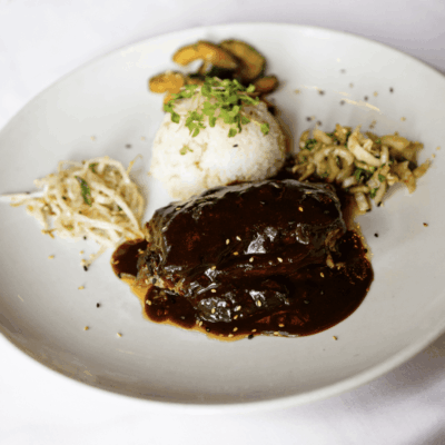 A plate of food with rice and meat on it.