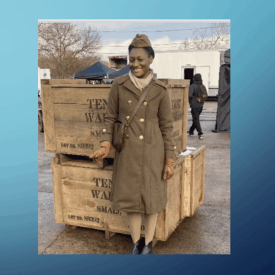 A woman in military clothing standing next to boxes.