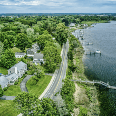Aerial view of riverside road and houses.