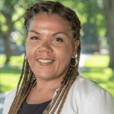 Smiling woman outdoors with braided hair.