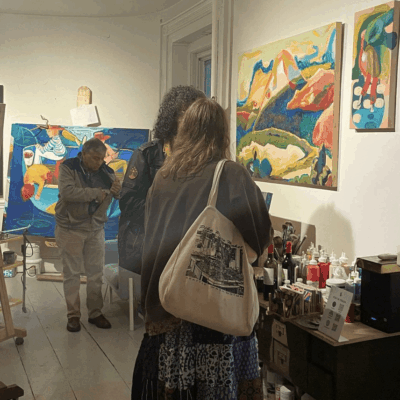 Art gallery visitors observing colorful paintings.