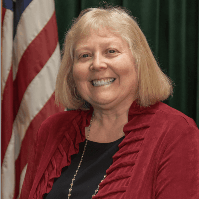 Smiling woman in red with American flag.