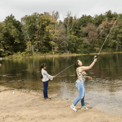 People fishing by a lakeside in autumn.