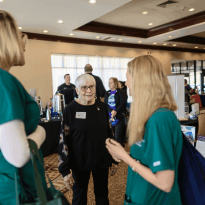 Three women talking at a conference event.