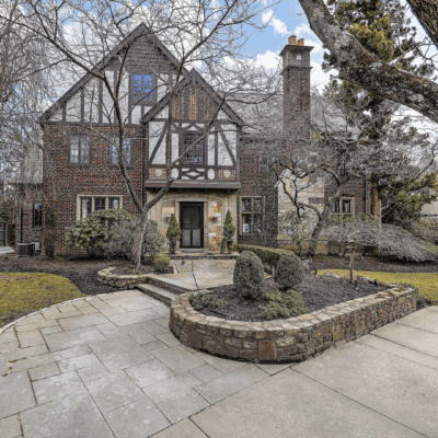 Tudor-style house with stone pathway and trees.