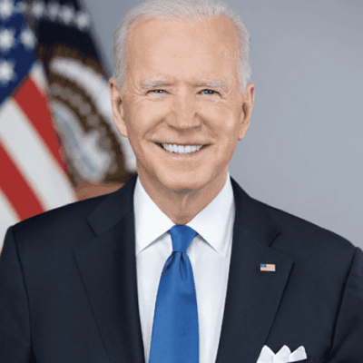 Smiling man in suit with American flag.