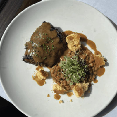 Steak with beans, cornbread, and garnish.