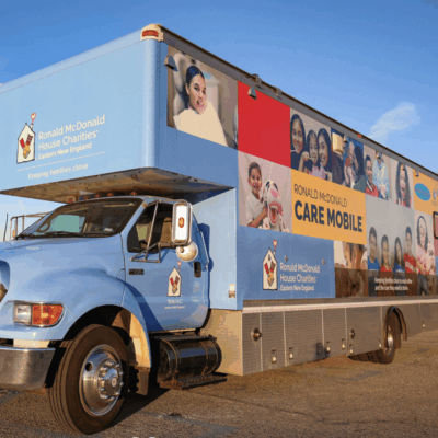 A large blue truck with posters on the side.