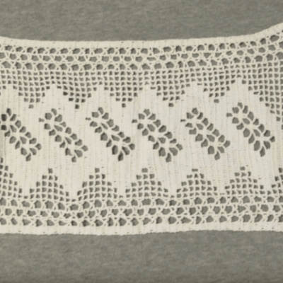 A white lace trim with a pattern of leaves.