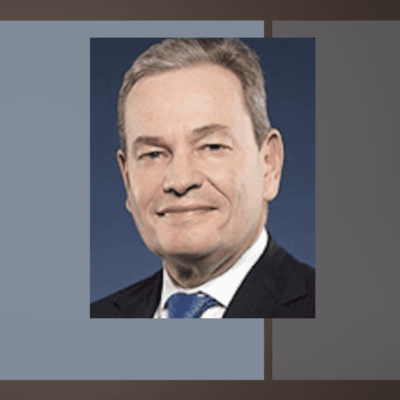 A man in suit and tie with a blue background