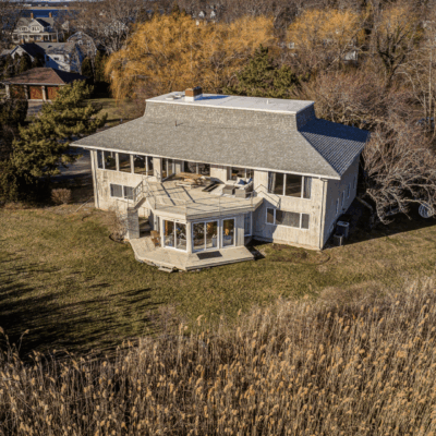 A large white house sitting on top of a grass covered field.