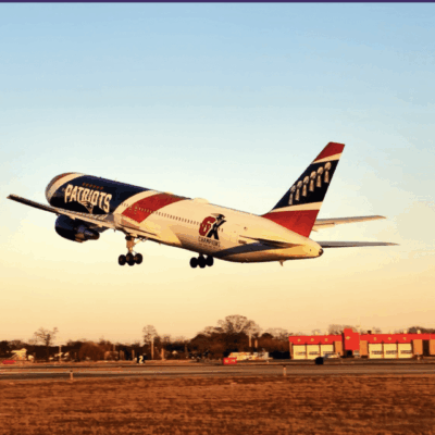A plane taking off with a clear sky and sunset lighting.