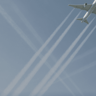 Four airplanes leaving contrails in the sky forming a crisscross pattern.