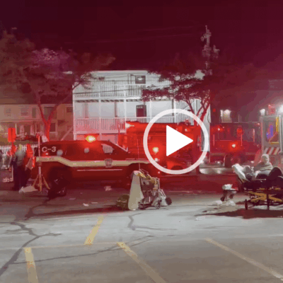 Emergency responders at a nighttime accident scene with a train and injured people.