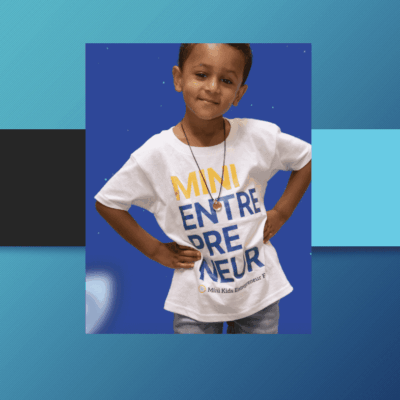 A young boy confidently posing in a white entrepreneur-themed T-shirt.
