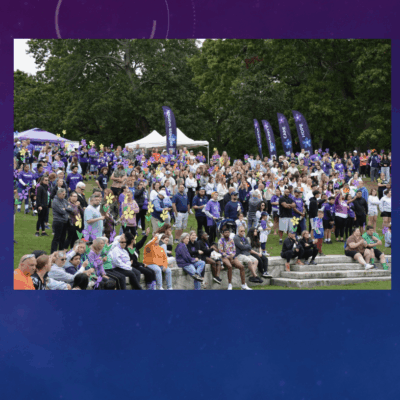 Large crowd gathered outdoors for an event on a sunny day.