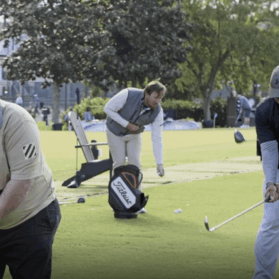People playing golf on a sunny day in a park.