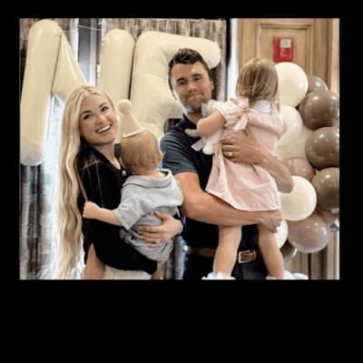 A joyful family moment with parents holding their two young children.