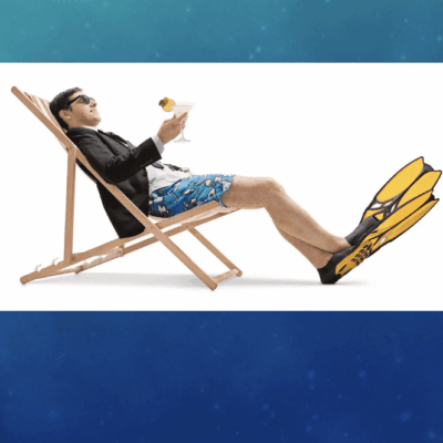 Man relaxing in a deck chair wearing snorkeling gear and holding a drink.