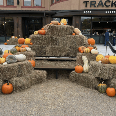 Autumn display with pumpkins and hay bales outside a restaurant.
