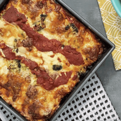 Freshly baked lasagna with melted cheese and tomato sauce in a baking tray.
