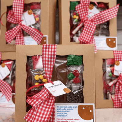 Gift boxes with festive red and white checkered ribbons on a wooden table.