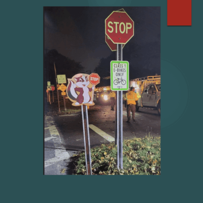 Multiple confusing street signs at a nighttime intersection.