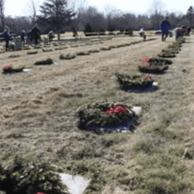 Graves decorated with wreaths in a cemetery on a winter day.