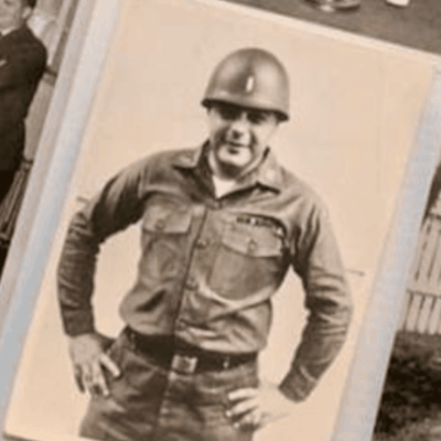 A smiling soldier in uniform and helmet poses confidently.