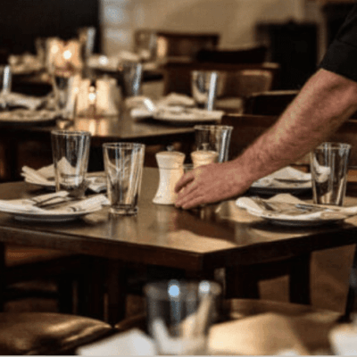 A waiter setting a table in a cozy restaurant.
