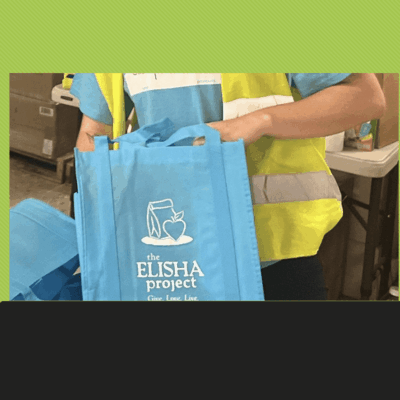 Cars line up at a drive-through food and essentials distribution hosted by The Elisha Project in Pawtucket