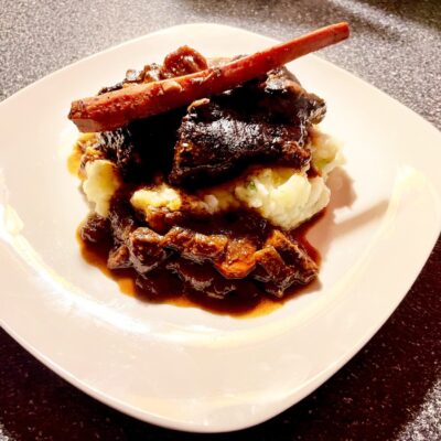 A plate with mashed potatoes and meat on it.