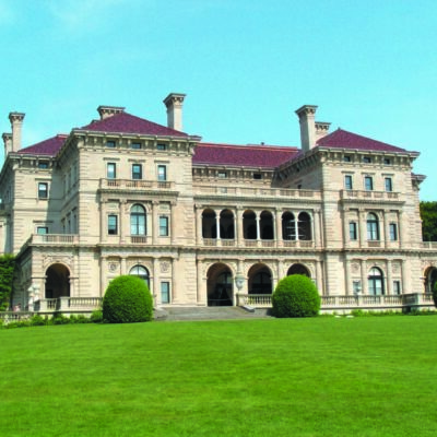 A large mansion on a green lawn.