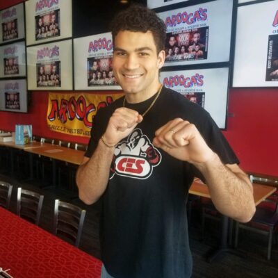 A man standing in front of a table with a boxing glove.