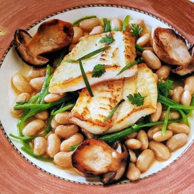 Pan-seared fish with beans and mushrooms.