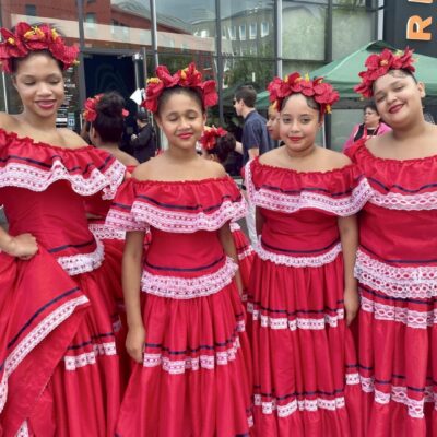 A group of mexican girls in red dresses posing for a photo.