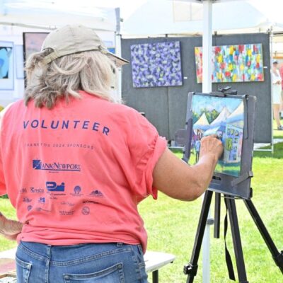 Volunteer painting outdoors on a sunny day.