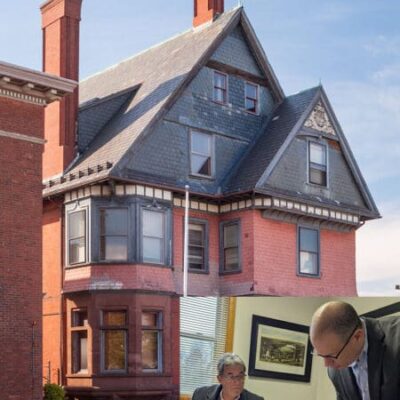 A man standing next to a pink house.