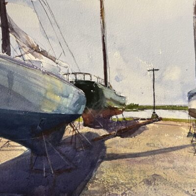 Boats on stands by a waterfront.