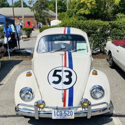 Classic white Volkswagen Beetle with racing stripes and number 53.