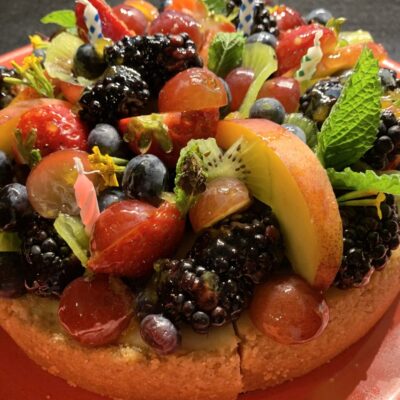 A cake topped with berries and mint.