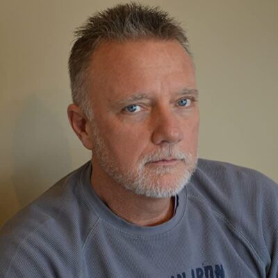 A man in a gray sweatshirt looking at the camera.