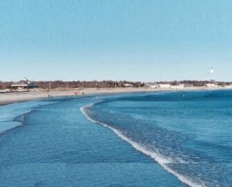 A beach with a lighthouse in the background.