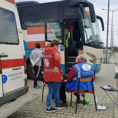 A group of people standing in front of a bus.