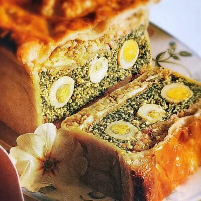 Sliced savory pie with eggs and spinach.