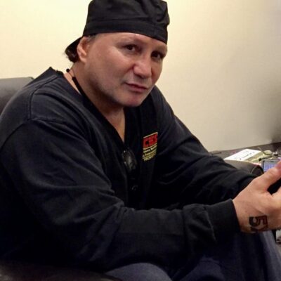 A man sitting in a chair holding a remote control.