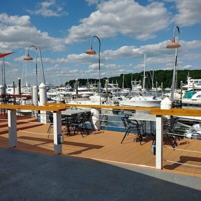 A deck overlooking a marina with boats docked, providing an ideal setting for networking and socializing.