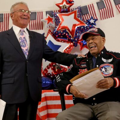 A man in a suit is standing next to a man in a suit.