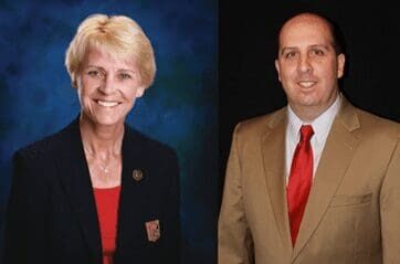 A man and woman in business attire are posing for a photo.